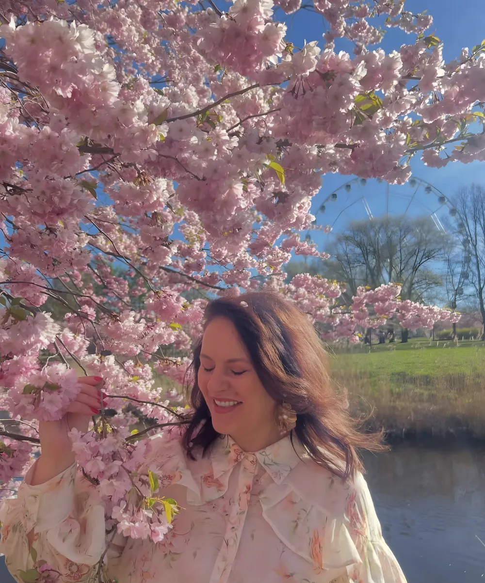Evija Rubina smaida, turot ziedošu sakuras zaru